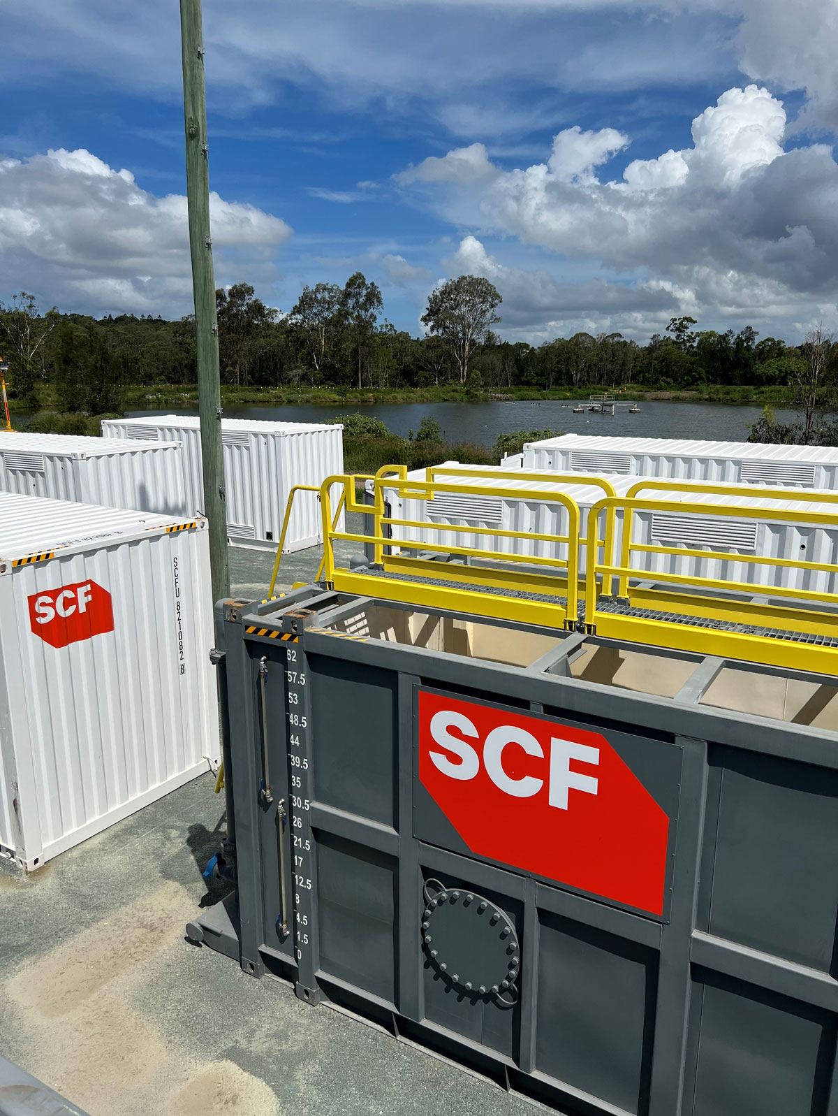 SCF Bulk Liquid tanks on site with shipping containers in the background